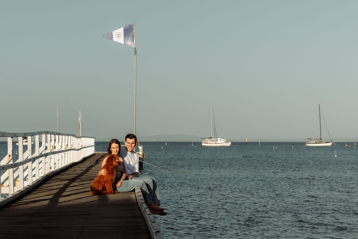 Panoramic collage of people enjoying a scenic pier overlooking calm waters with sailboats in the distance.