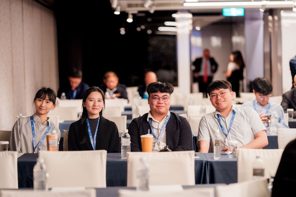 Attendees seated at white tables during a professional conference or corporate training session.