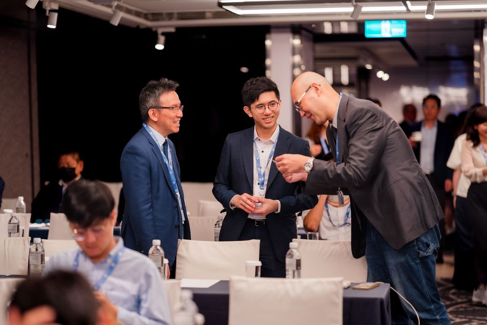 Business professionals network and engage in conversation at a modern indoor corporate event space.