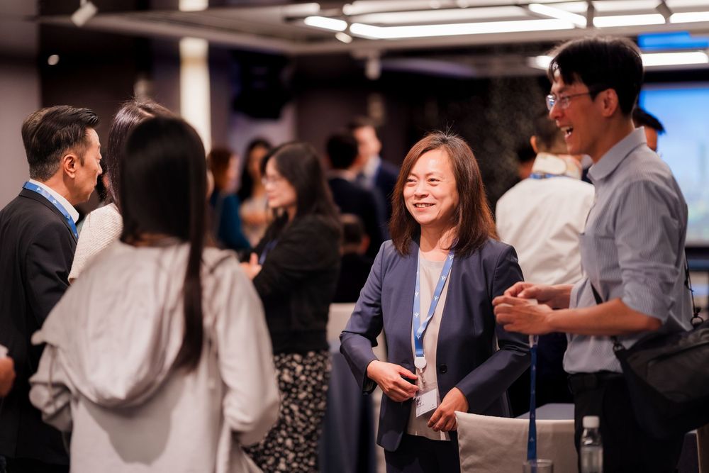 Professionals networking and mingling at a business social event in a modern office space.