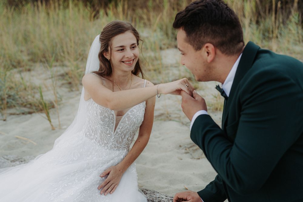 Romantic wedding couple sharing a tender moment together on sandy beach during their special day.