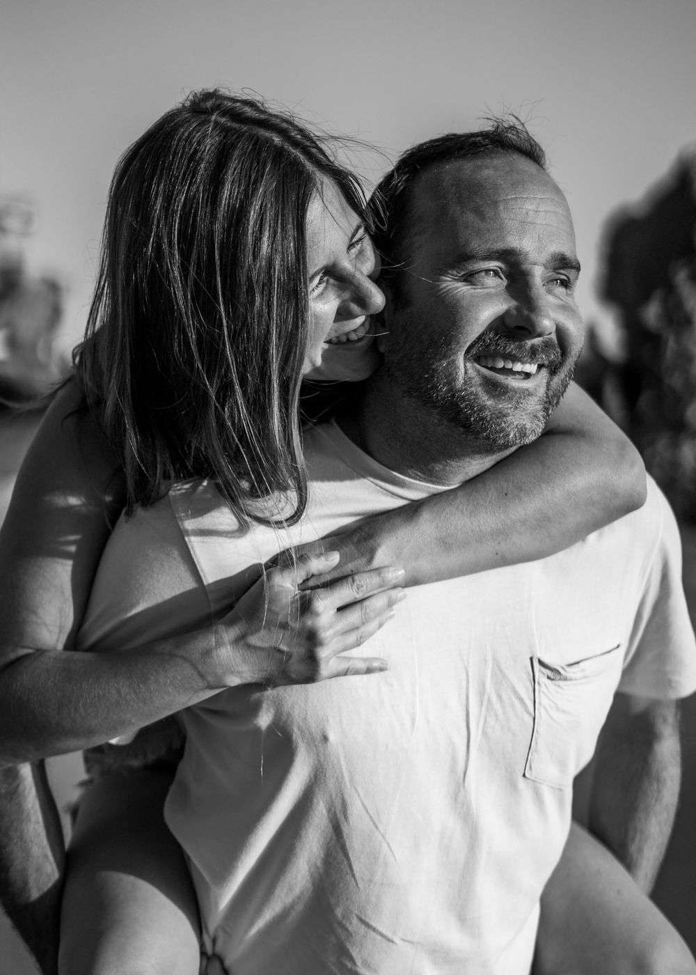 A series of black and white photographs showing a couple embracing and laughing together in candid moments.