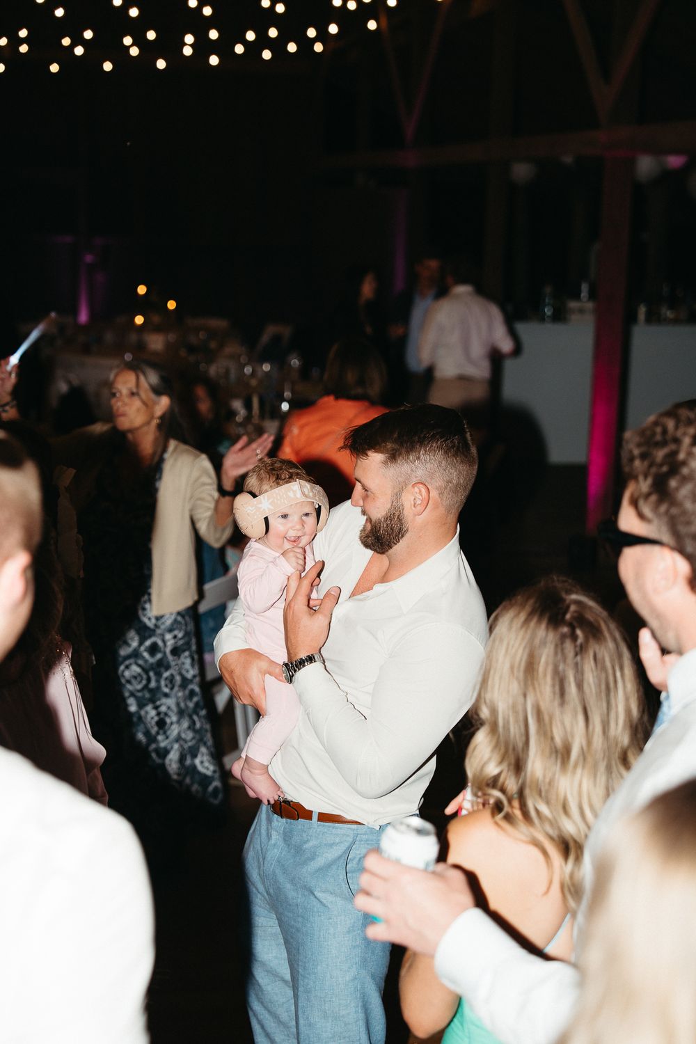 People dancing and celebrating at wedding reception - North Carolina wedding venue with twinkling lights in the background. Camp Pinnacle
