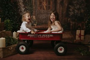 Red wagon lifestyle photoshoot with family members enjoying quality time together in a warm indoor setting.