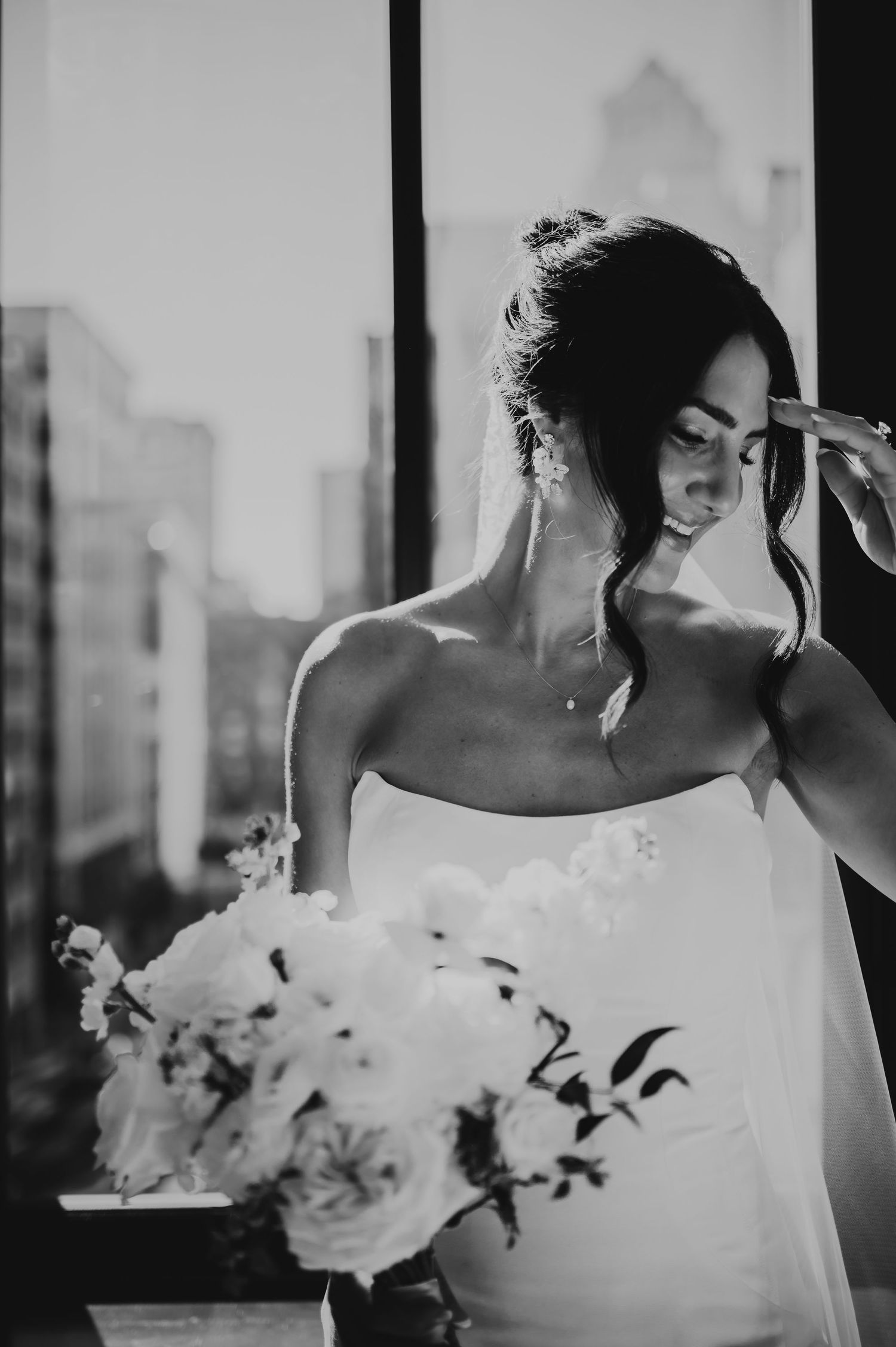 Black and white artistic wedding photo series showing a bride with flowers in elegant poses by a window.