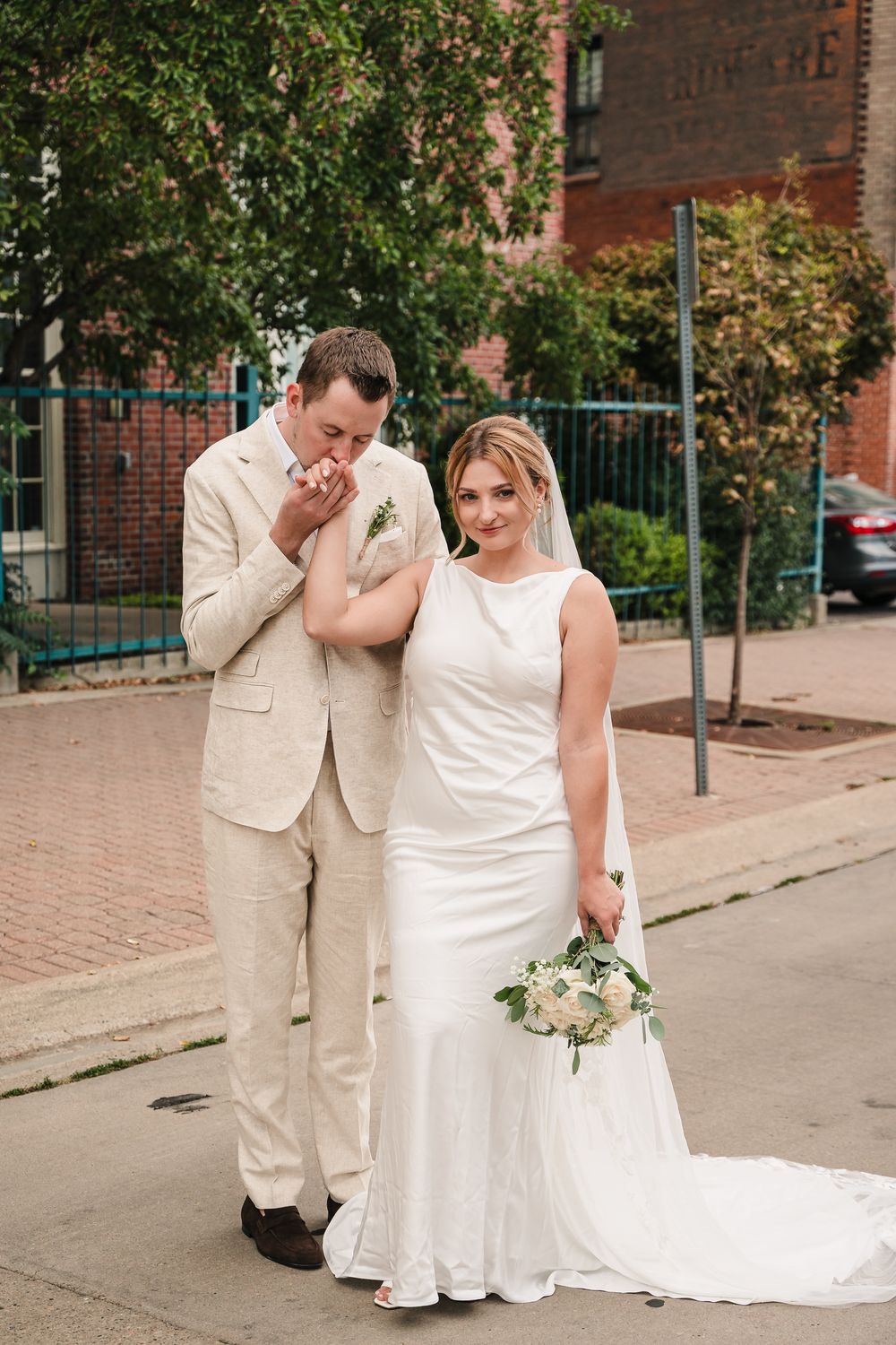 A couple shares an emotional first look moment on their wedding day wearing cream and white attire.