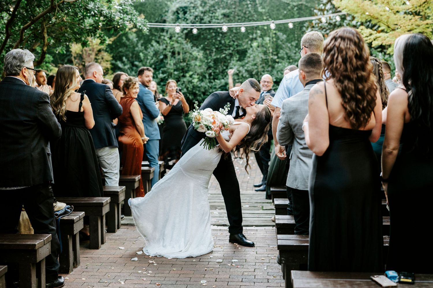 Wedding guests celebrate on an outdoor dance floor during a joyful reception celebration.