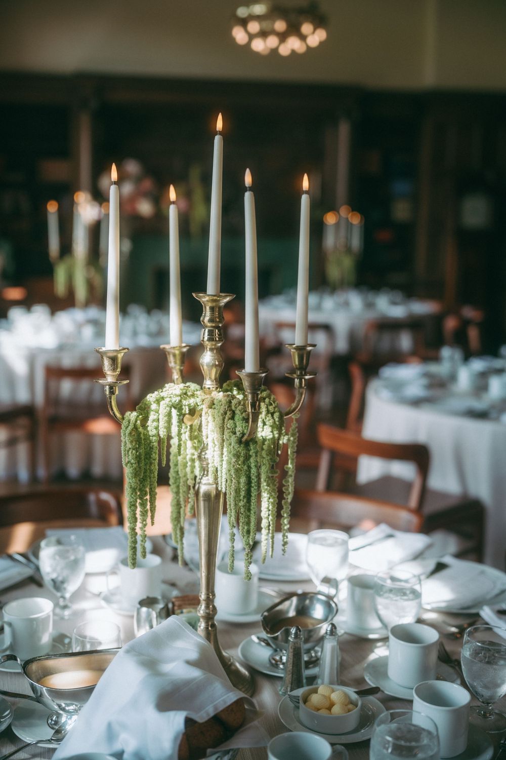 Elegant table setting with tall candelabra centerpiece and hanging amaranthus.