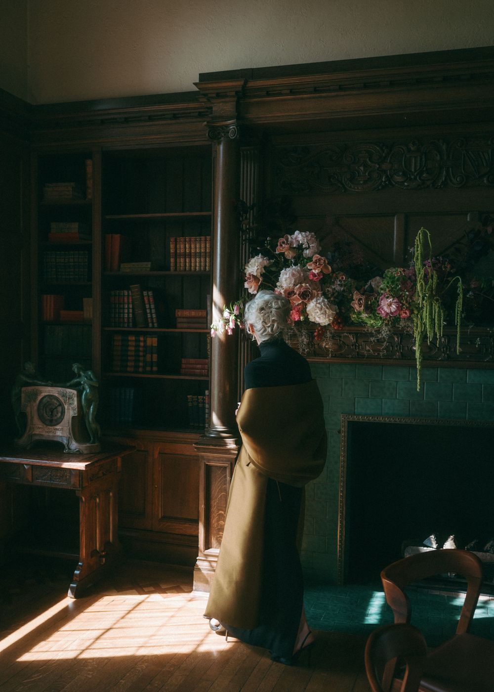 Sunlit library room with wooden shelves and elegant furniture casting dramatic shadows.