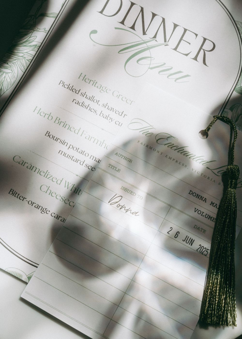Close-up details of an elegant dinner menu with decorative tassels and calligraphy.