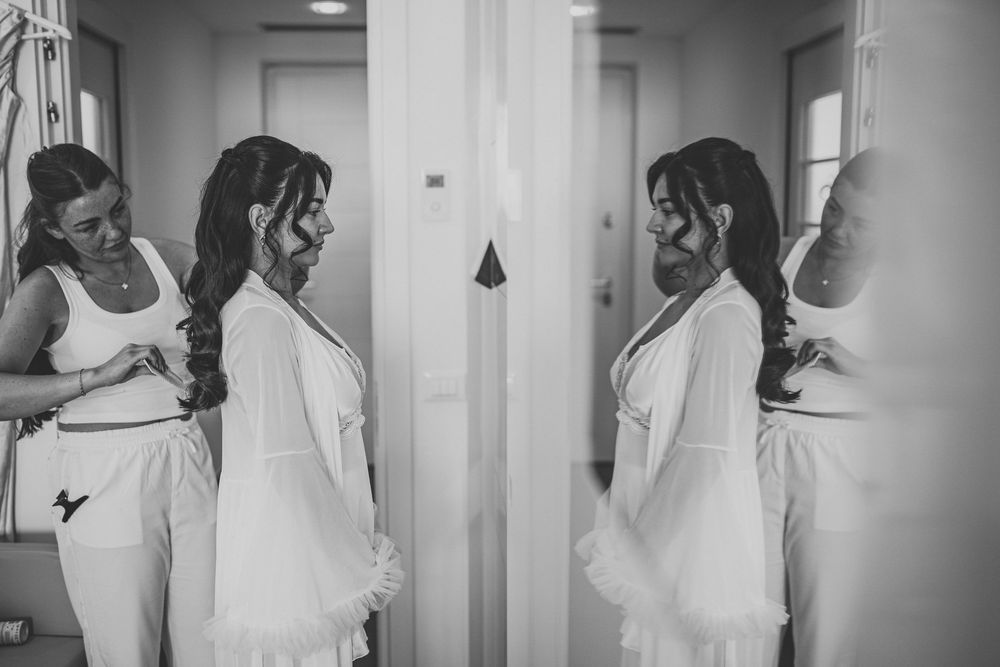 Black and white image showing wedding preparations in a hallway.