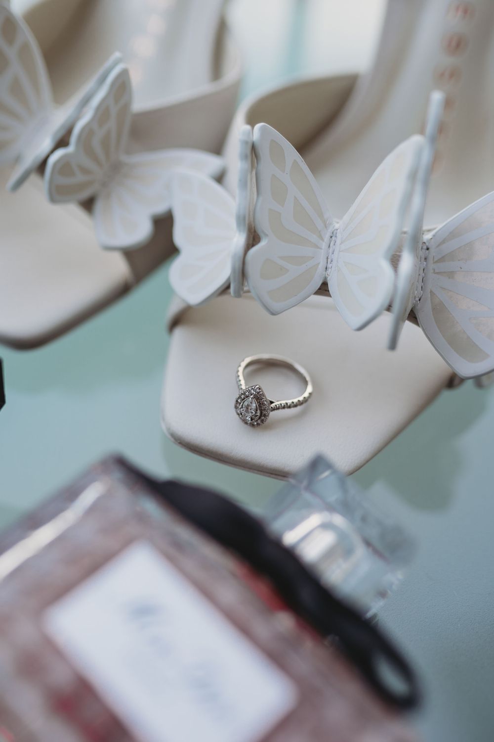 Close-up details of elegant white wedding shoes against a light background.