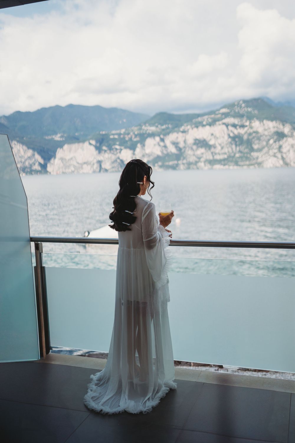 Wedding dress silhouette against a scenic mountain and lake backdrop.