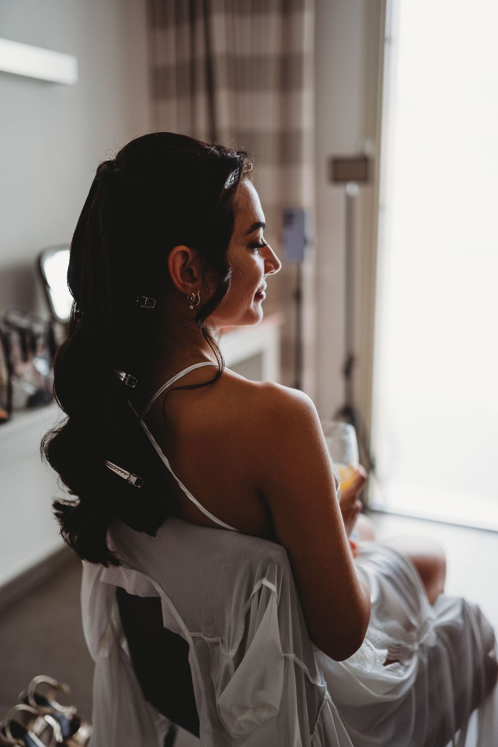 Silhouette of someone getting ready in a bright, sunlit room.