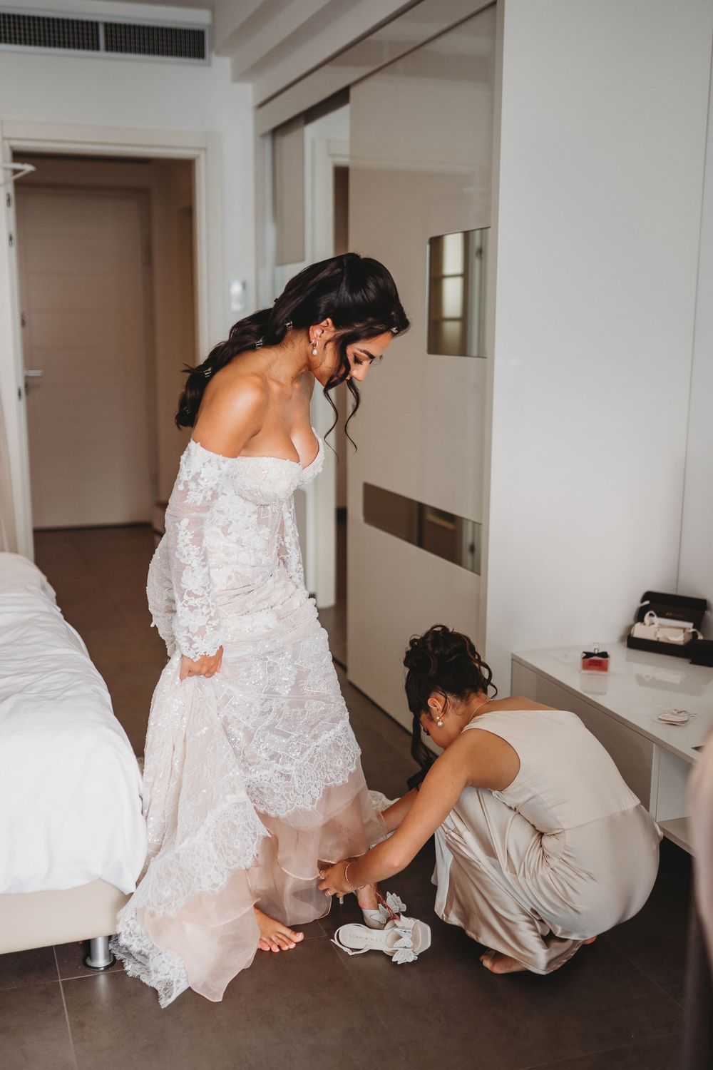 Wedding dress being adjusted and fitted in a modern interior setting.