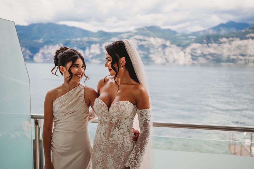 Wedding couple posing against a scenic mountain and lake backdrop.