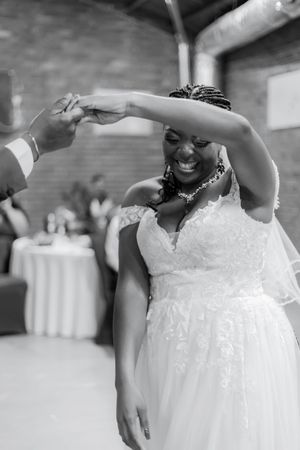 A joyful moment on the dance floor as the bride twirls in her lace and tulle wedding gown.