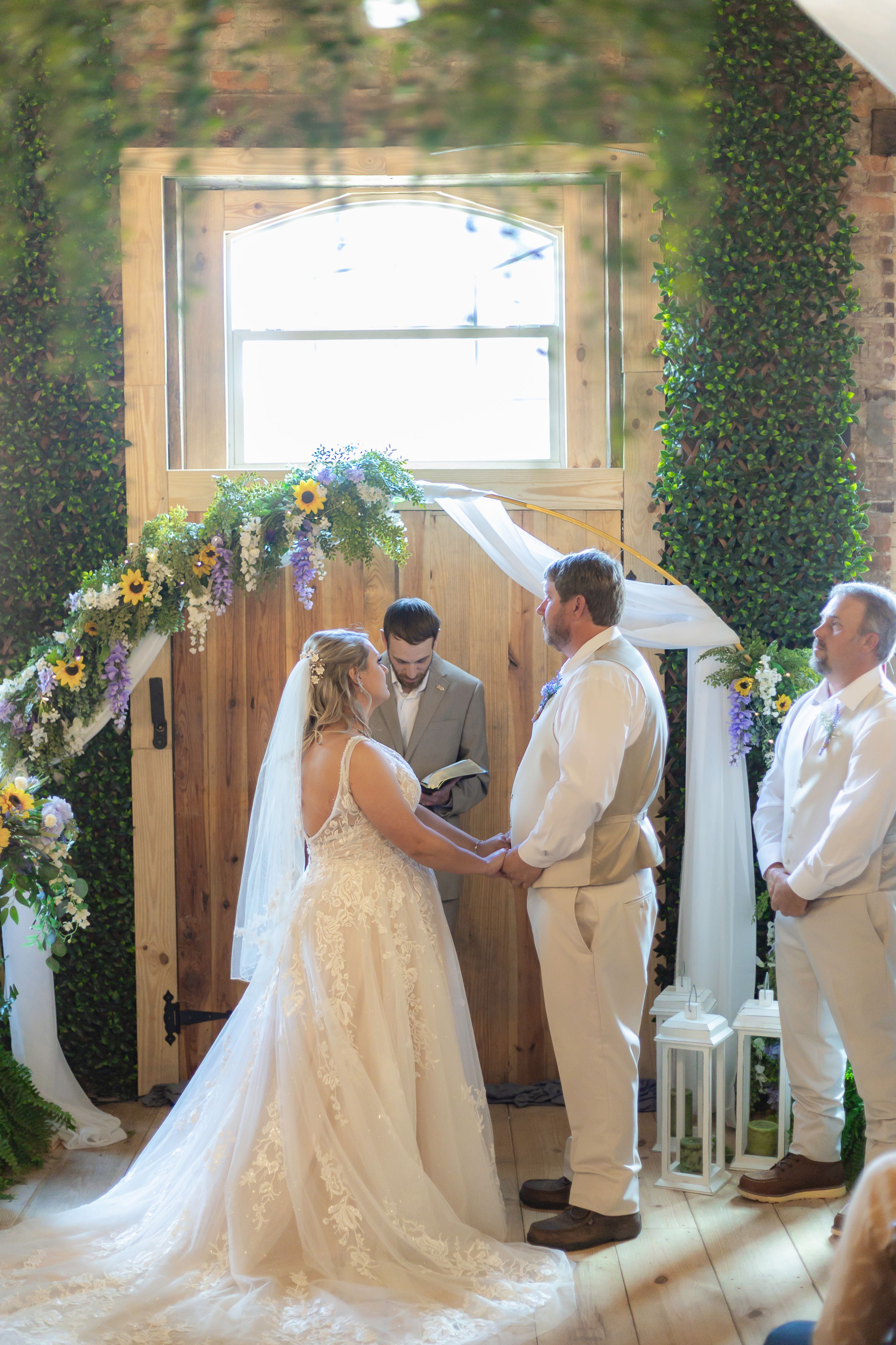 A wedding ceremony sequence showing a couple exchanging vows in a rustic indoor venue decorated with greenery.