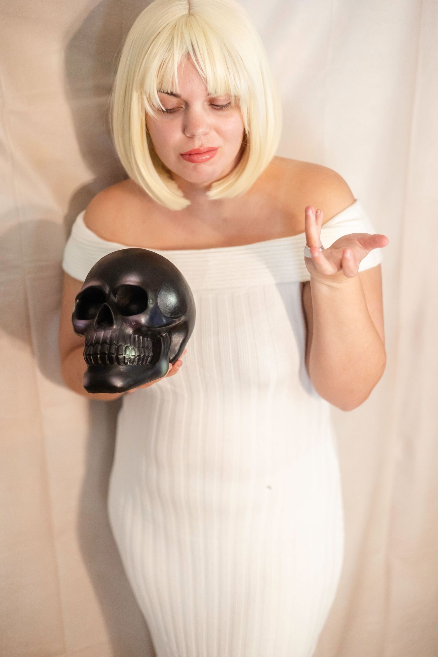 woman in a white dress poses with a large black shovel cosplays as Debbie from Addams Family Values Halloween Costume Photoshoot