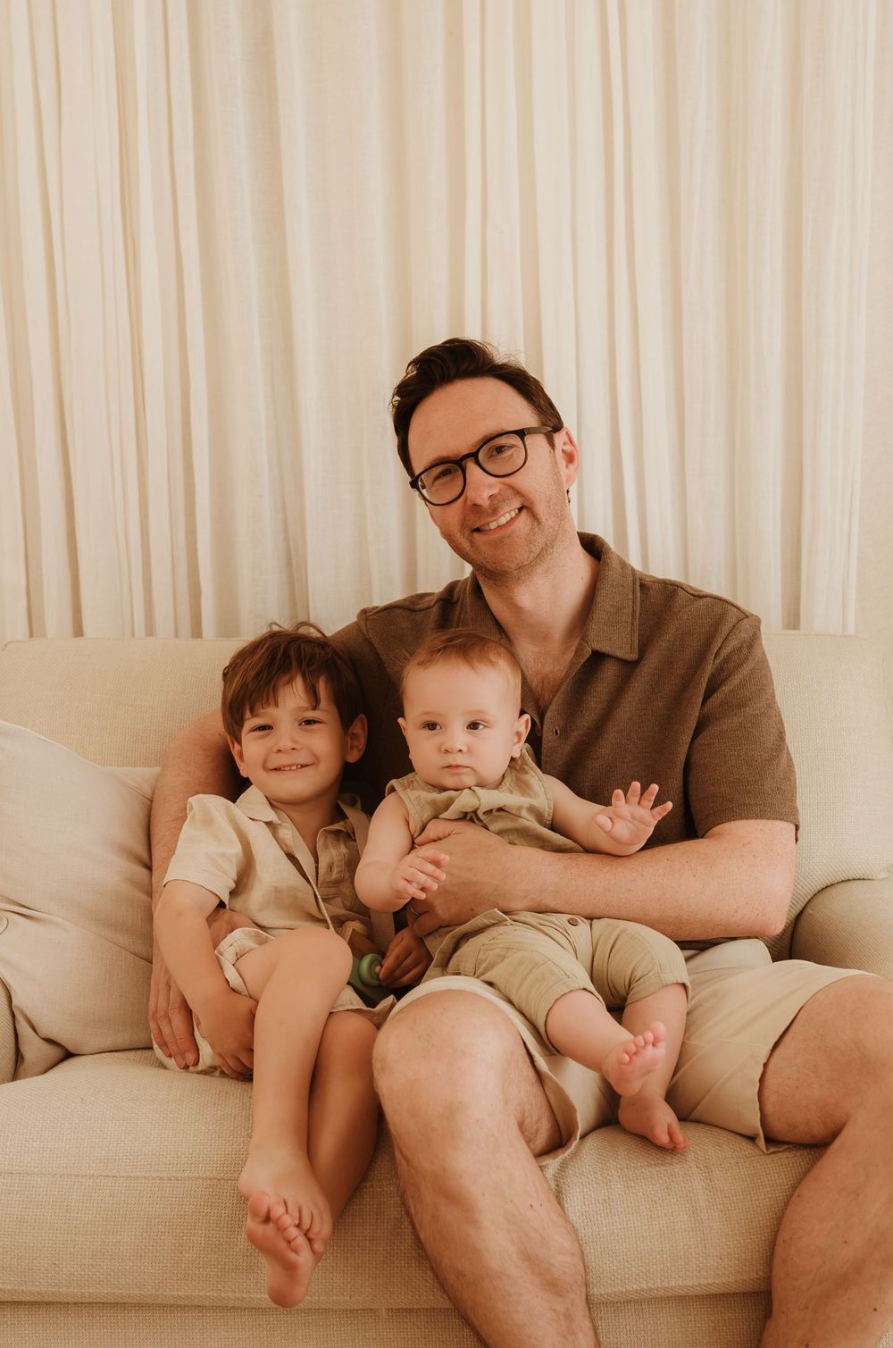 A family relaxes comfortably together on a cream-colored couch in a series of connected candid photos.