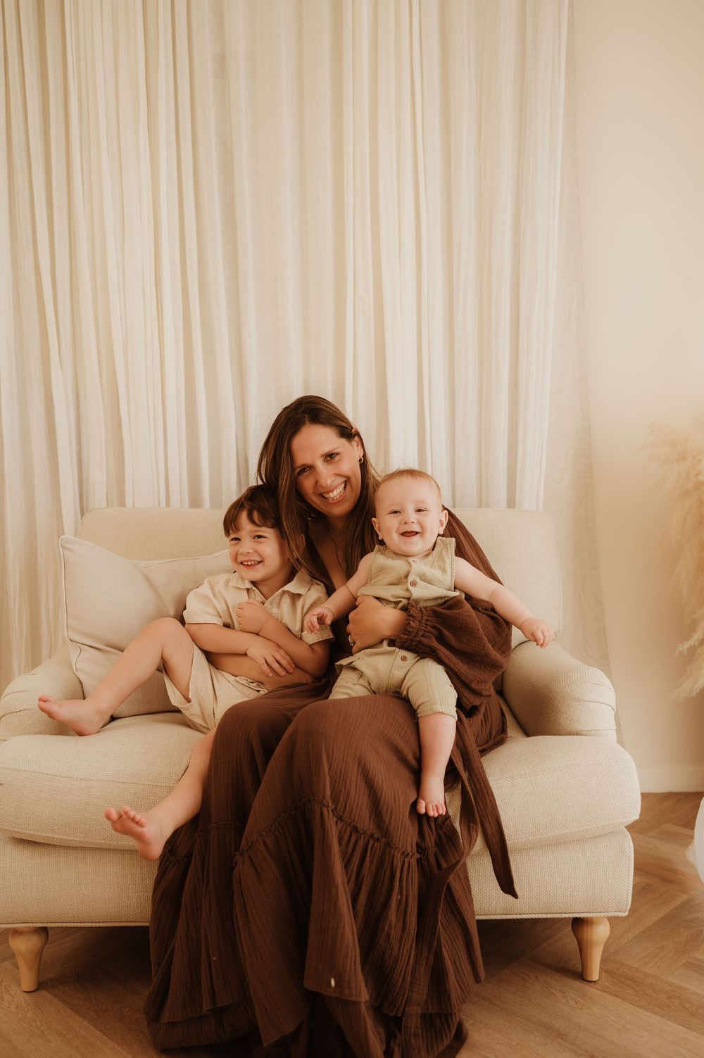 Series of family moments shows playful interactions on a cream colored couch against a neutral curtain backdrop.