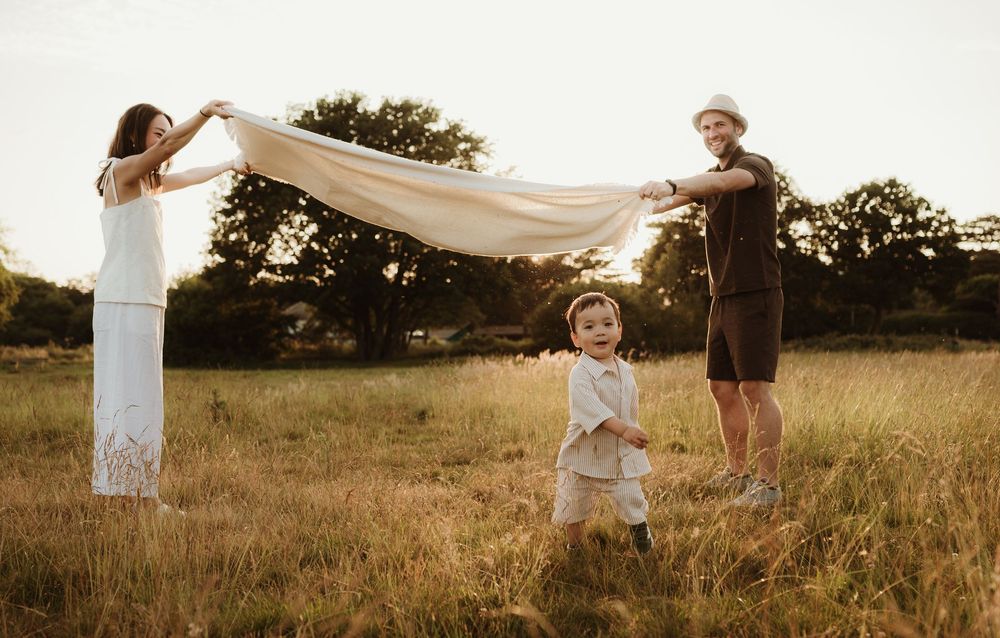 A series of sepia-toned images showing family moments in a sunlit field during golden hour.