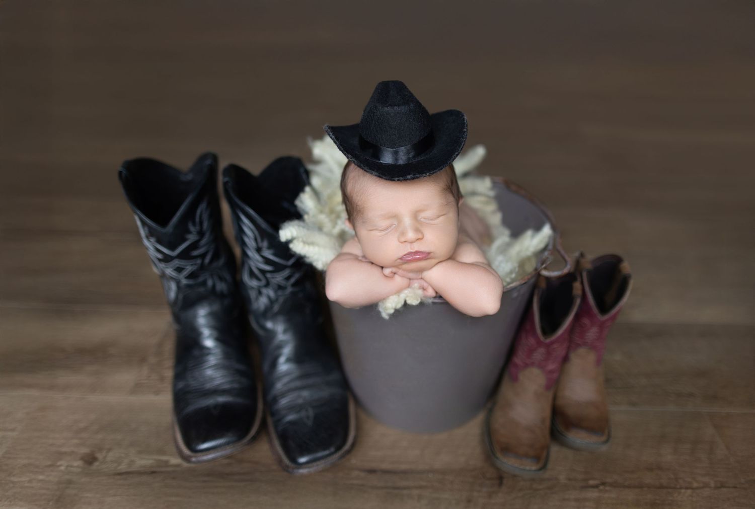Newborn photography with cowboy boots and hat on wooden background. Photos by Tampa Photographer DigitalMyst Photography