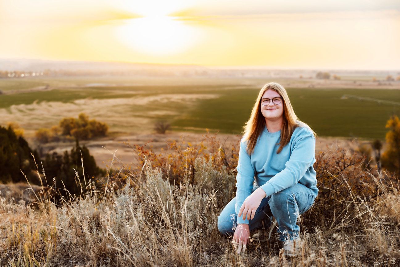 Vanessa Phillips Photo - Billings, MT Photographer - A senior photo taken of a boy kneeling with a beautiful backdrop.