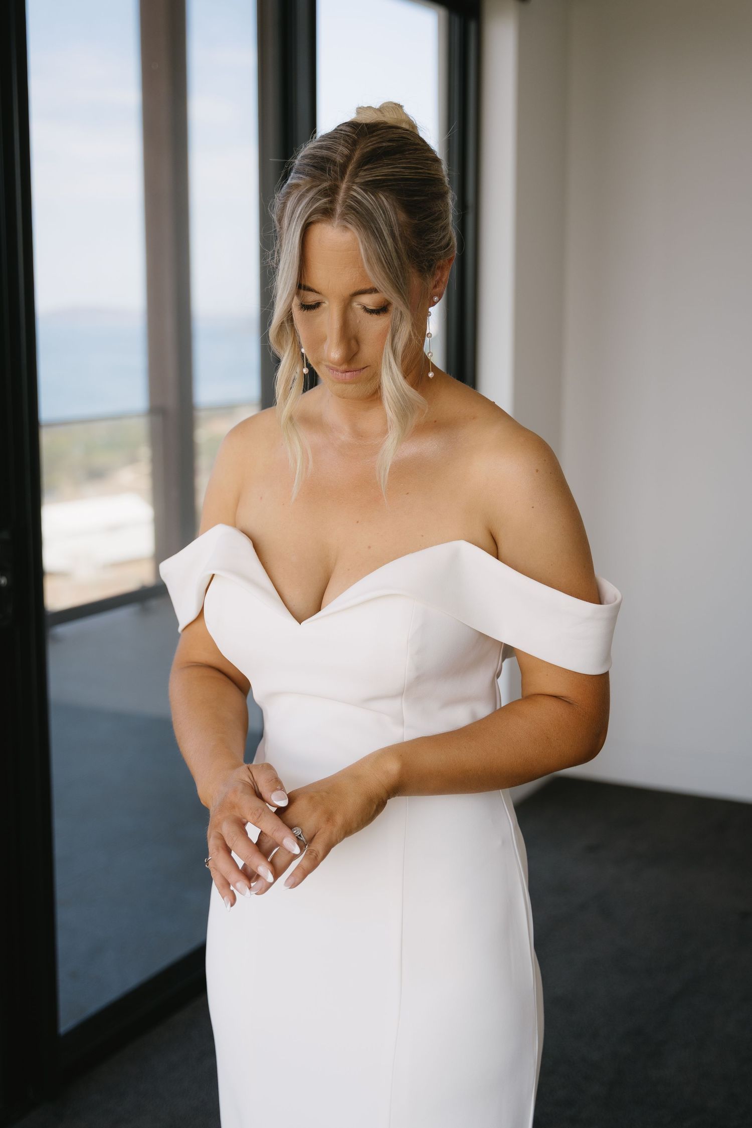 Close-up shots of a wedding dress being adjusted in a bright modern room.
