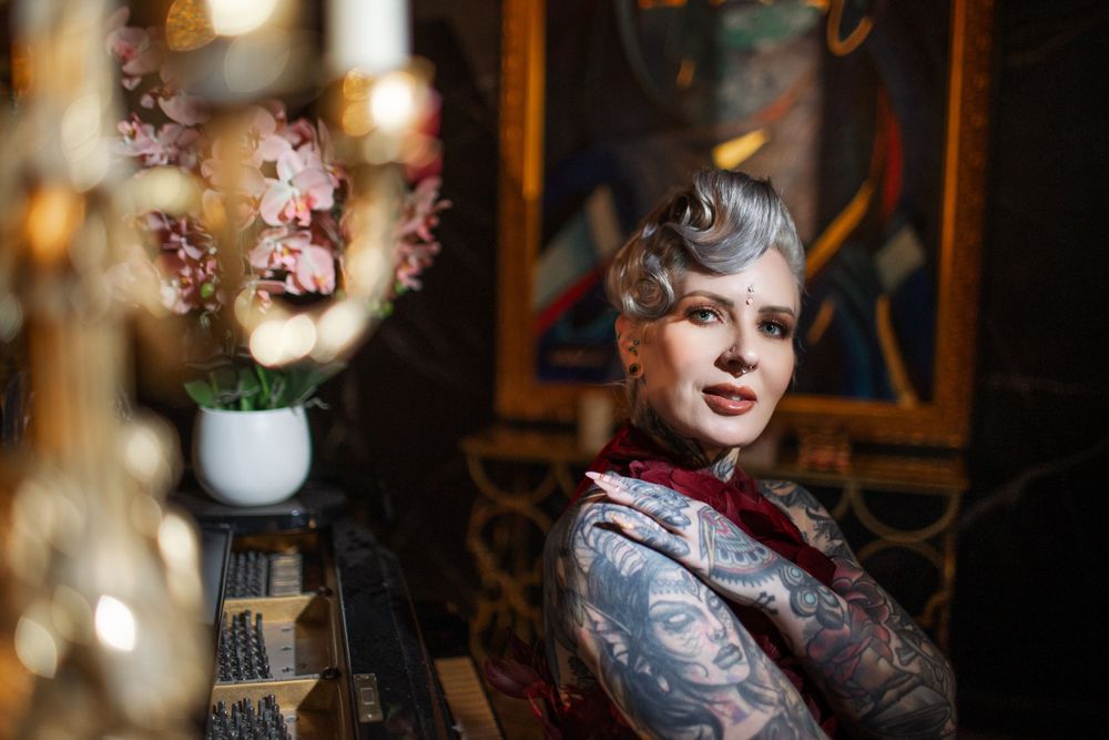 Elegant vintage style portrait in restaurant setting with lilac flowers and bokeh lighting effects.