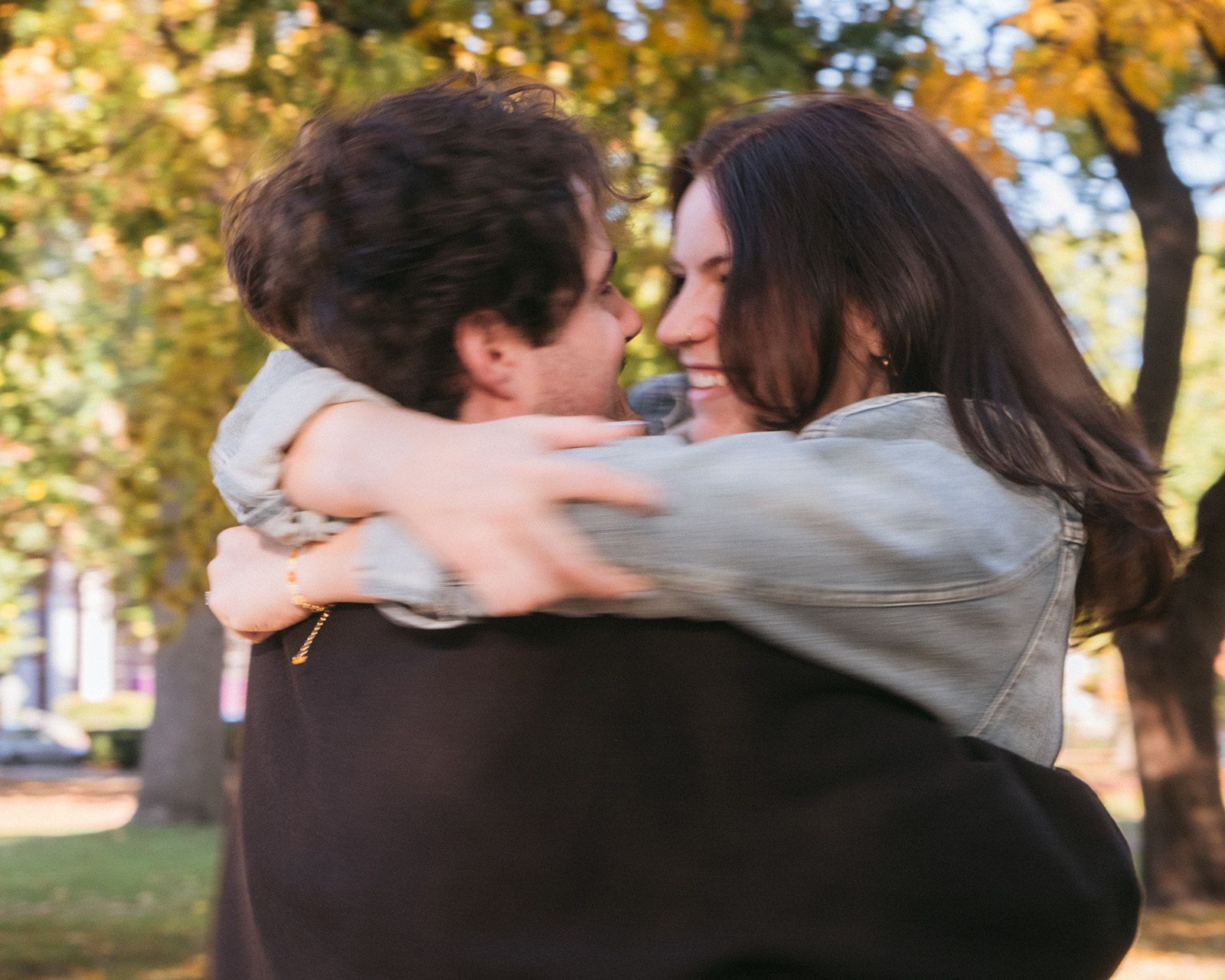 Intimate embrace captured during autumn with golden leaves in the background.