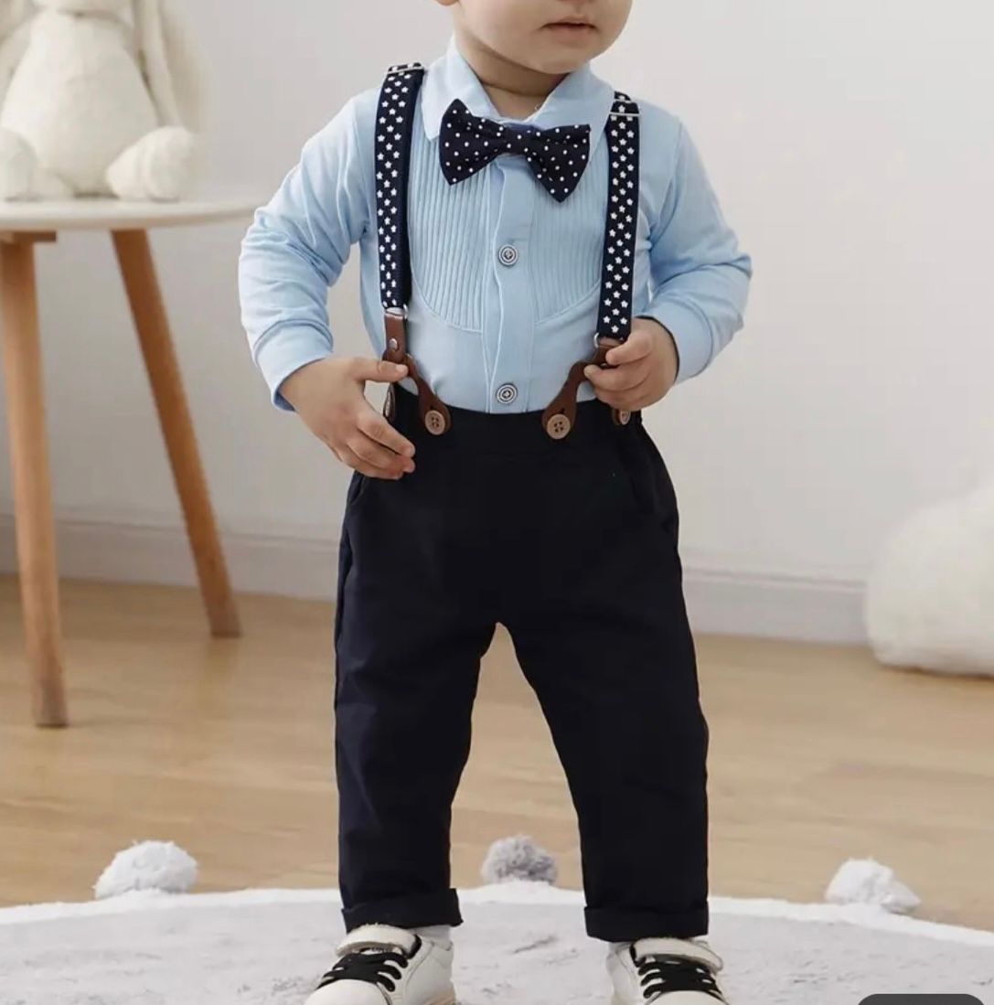 Stylish baby outfit featuring black suspenders, polka dot bow tie, and light blue button-down shirt.