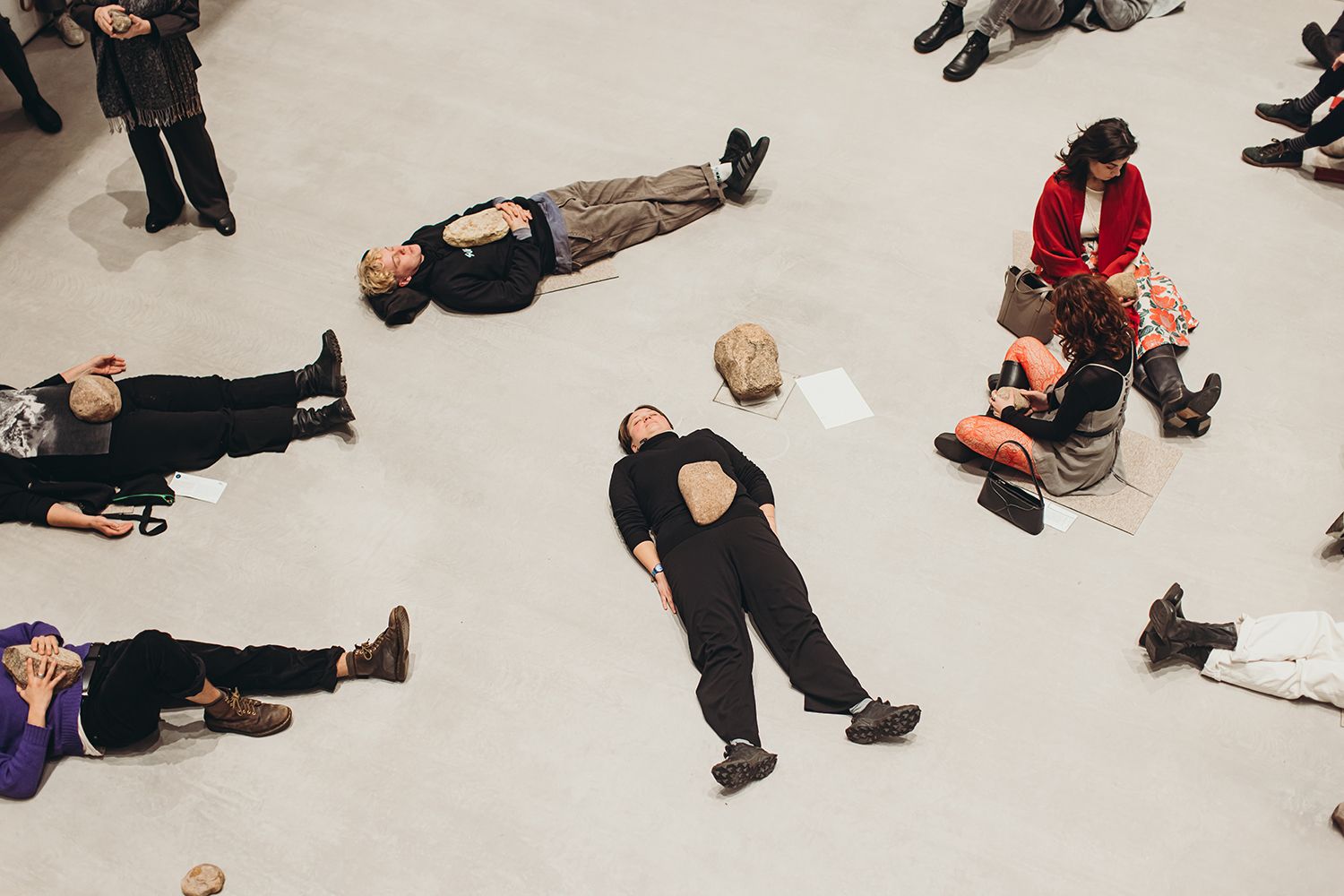 People lying on the floor in an artistic arrangement during an event.