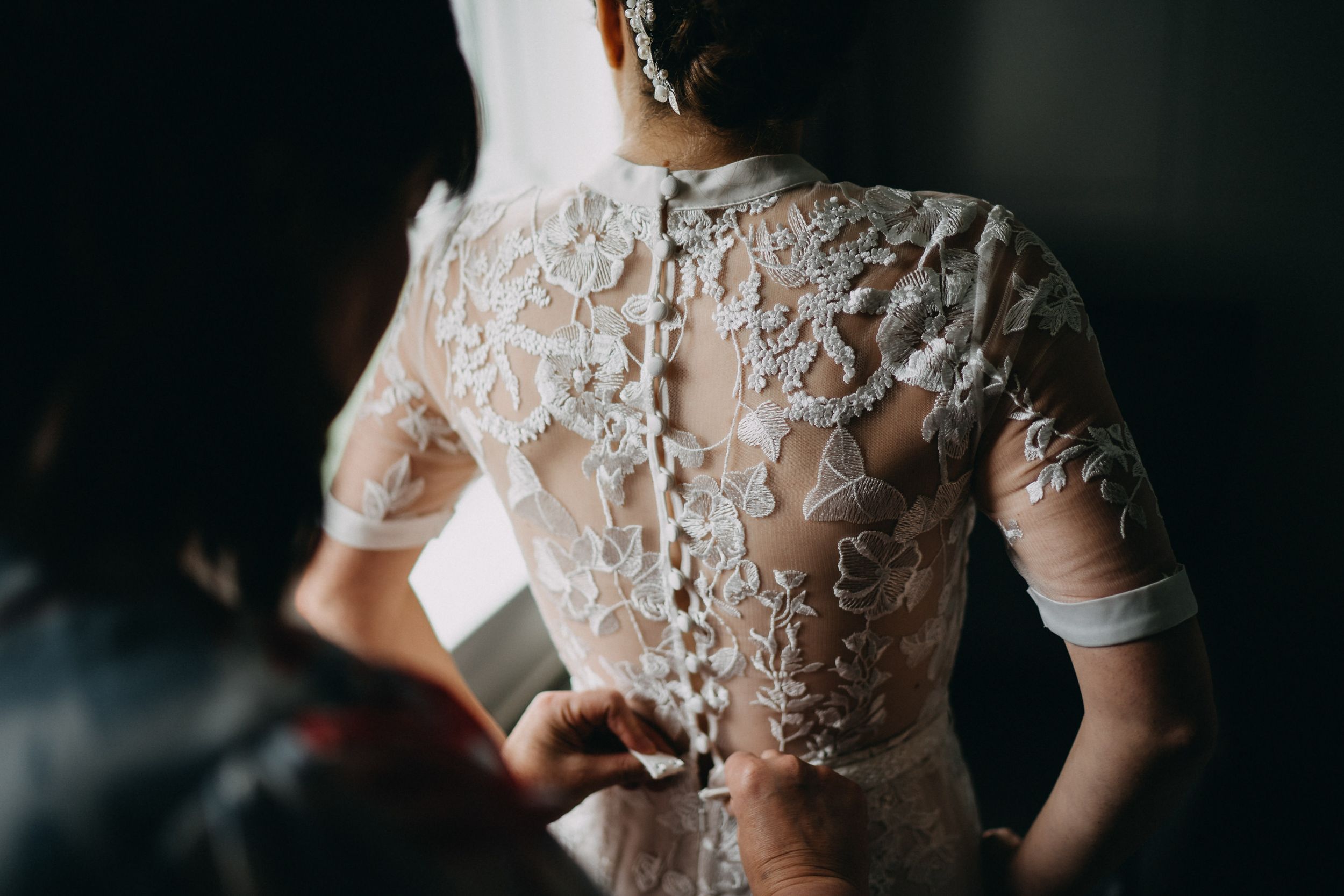 Detailed lace back of a vintage-style wedding dress with delicate button details.