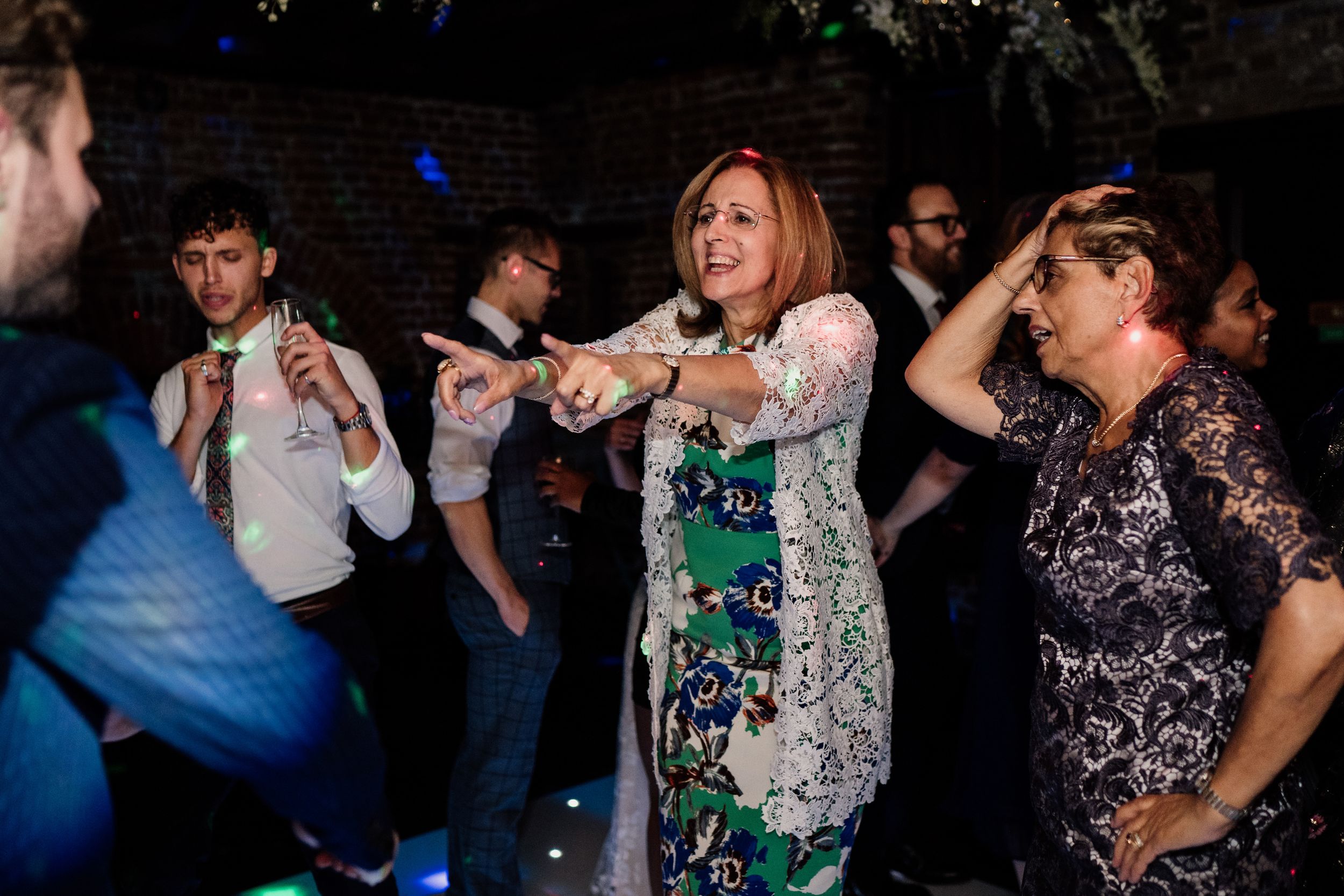 Energetic guests dancing together at a lively reception party.
