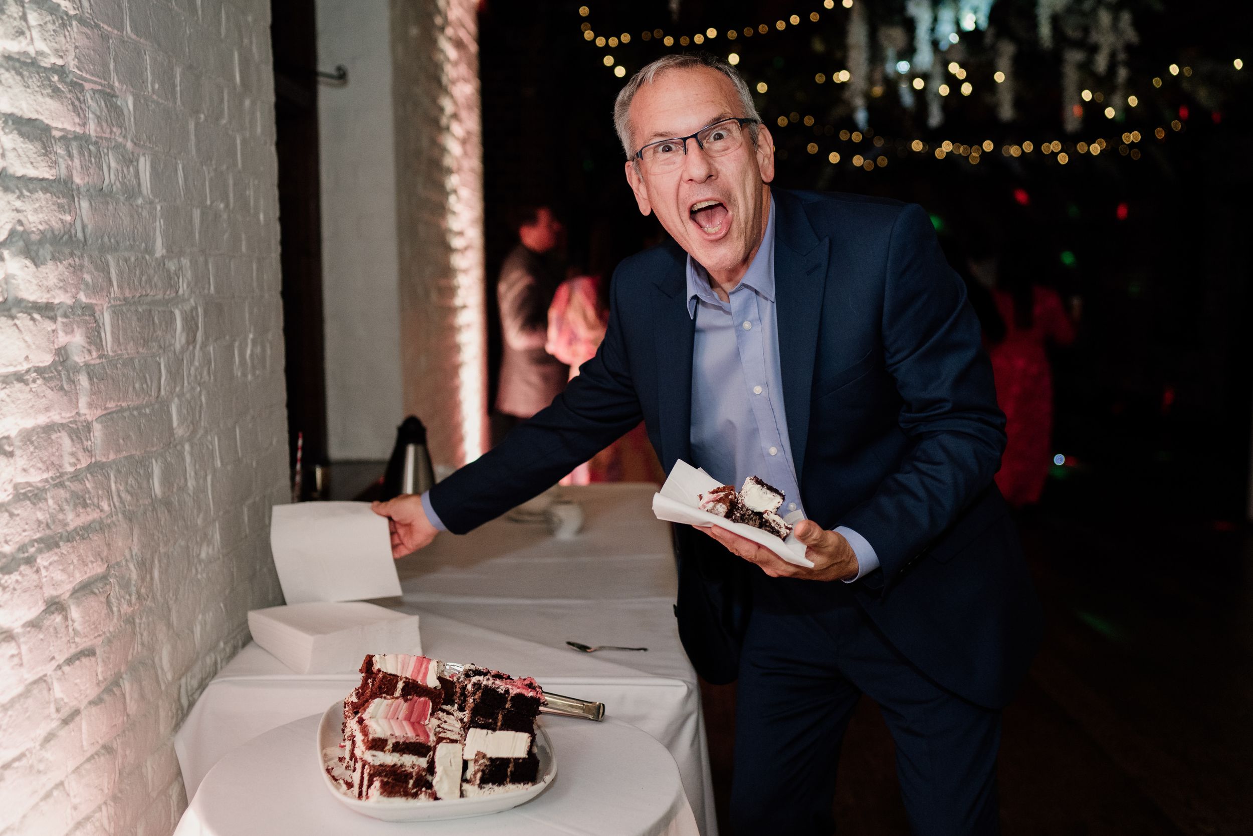 Guest reacting excitedly at dessert table during reception.