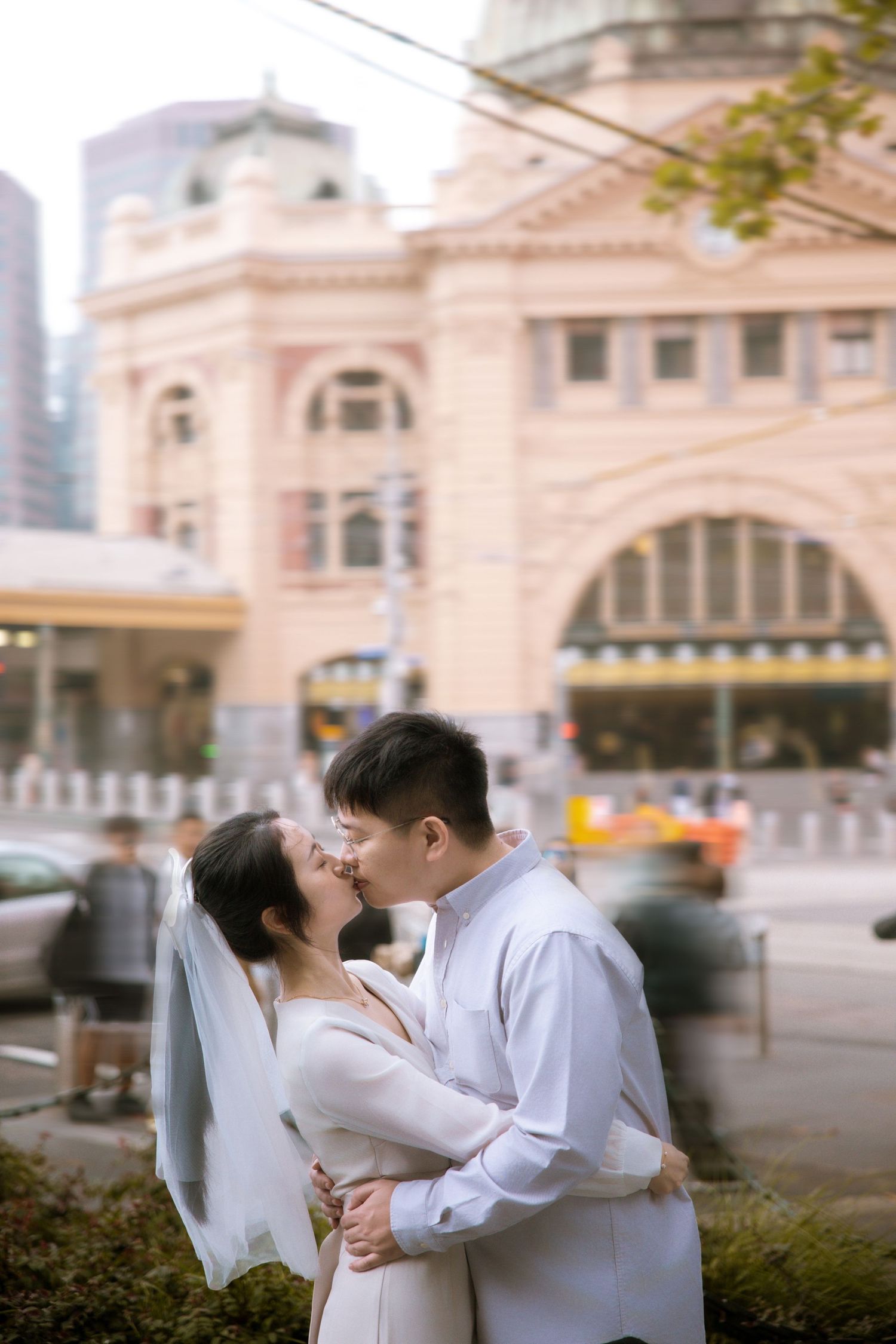 An intimate wedding portrait in front of Melbourne's iconic Flinders Street Station.