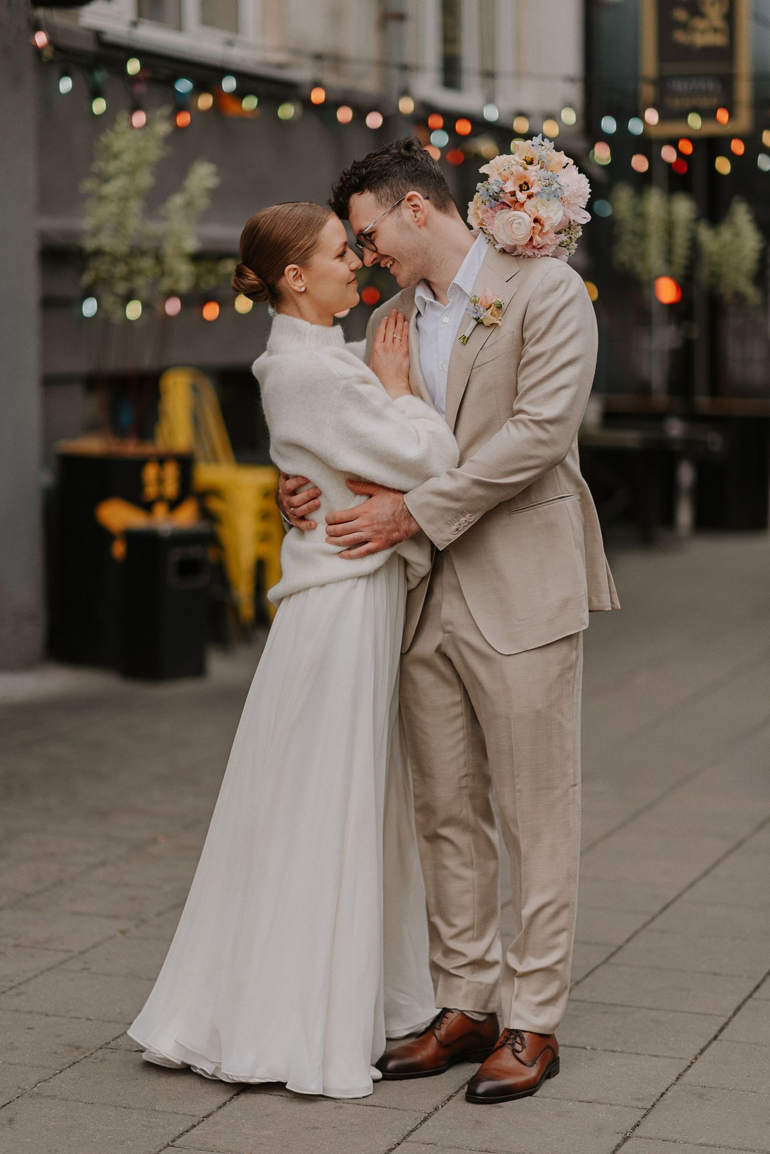 Urban wedding photos with string lights showing intimate moments between newlyweds.