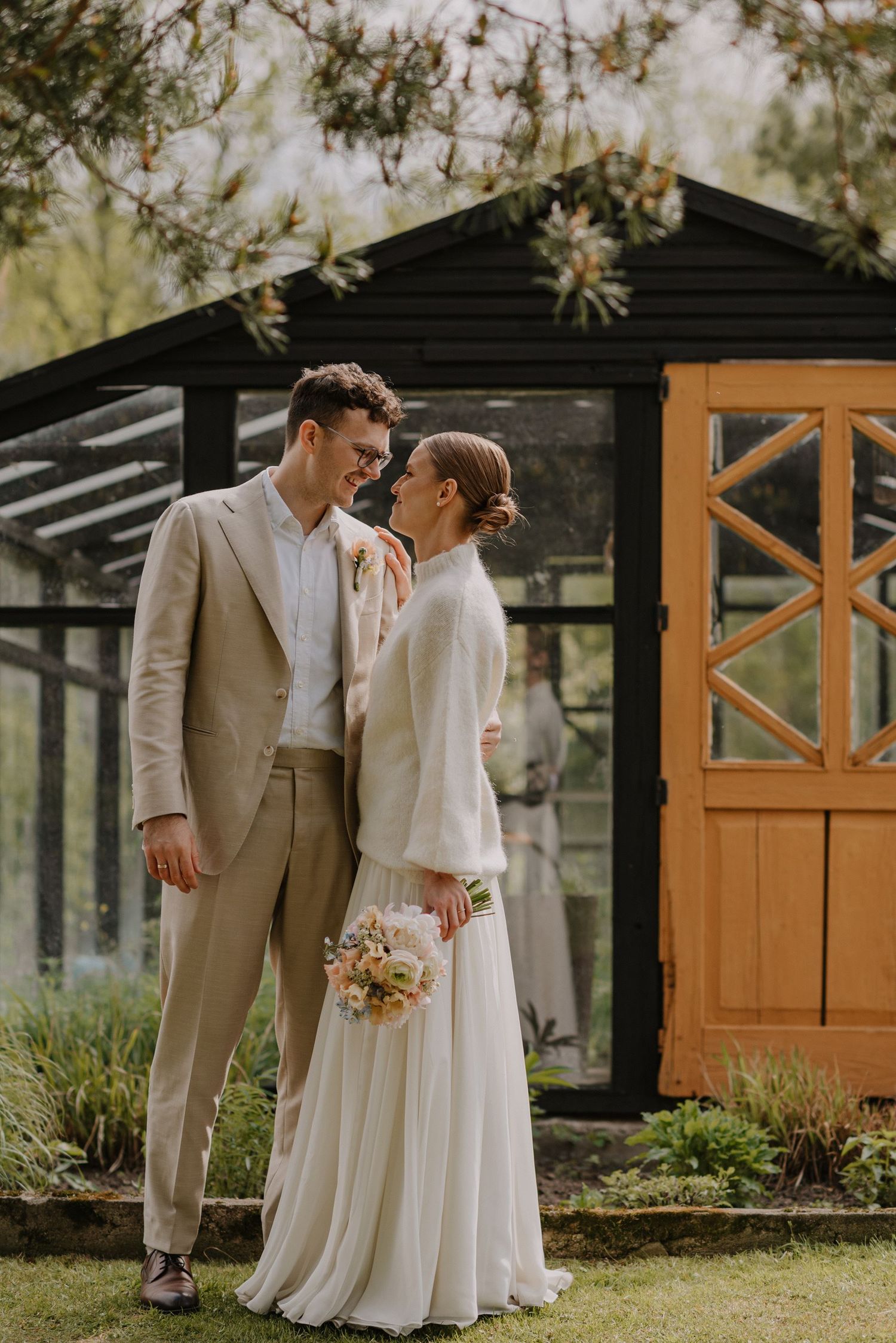 Garden wedding portraits featuring a rustic cabin backdrop and natural lighting.