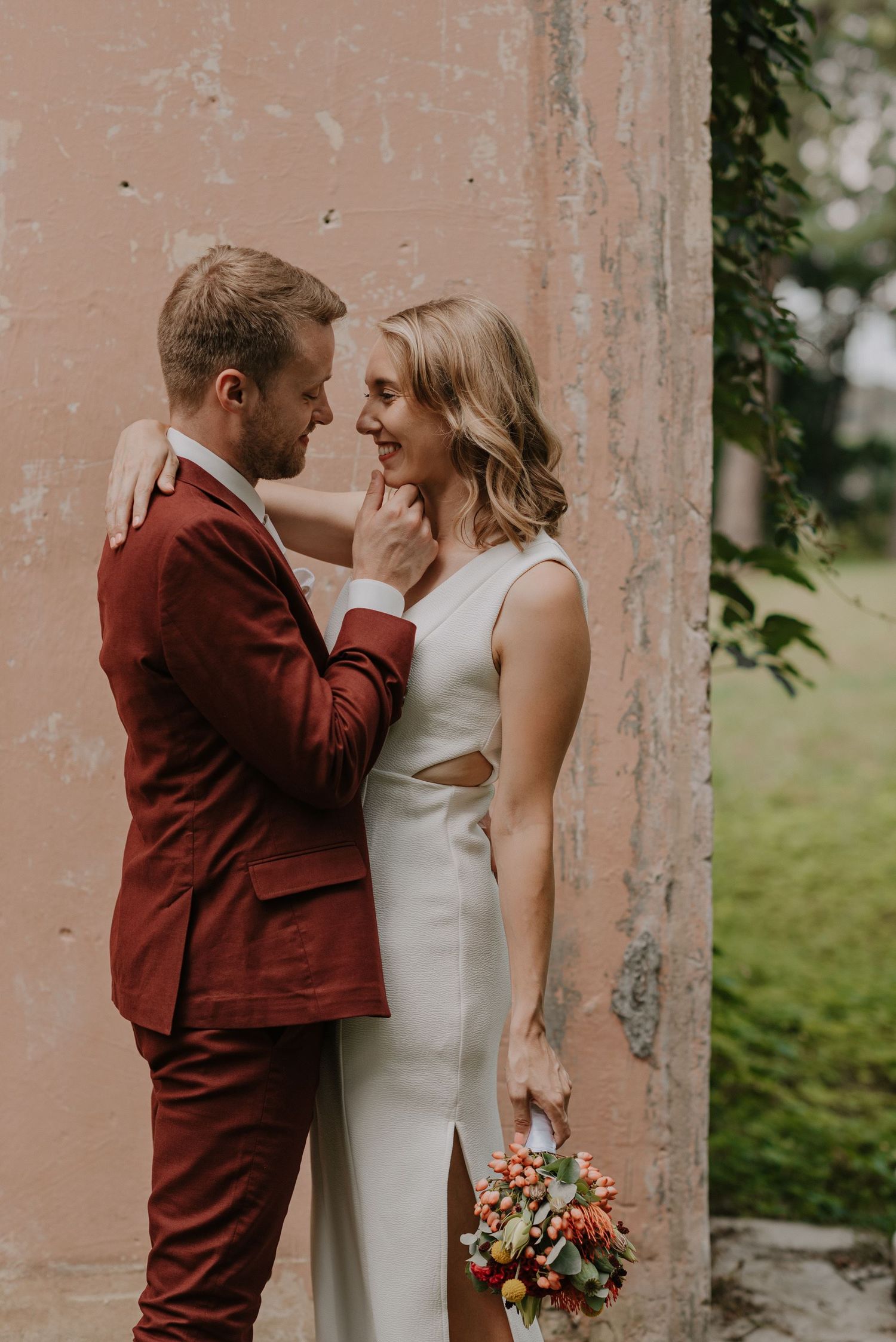A romantic wedding photoshoot series showing tender moments and expressions of joy against pink pillars.