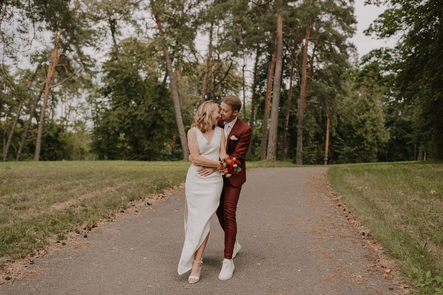 A pathway through a park with lush greenery and trees where a romantic photoshoot takes place.