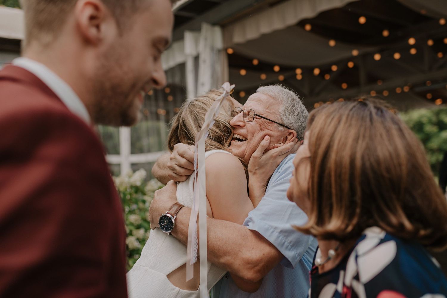 Wedding celebration captured with string lights and outdoor setting showing joyful reactions.