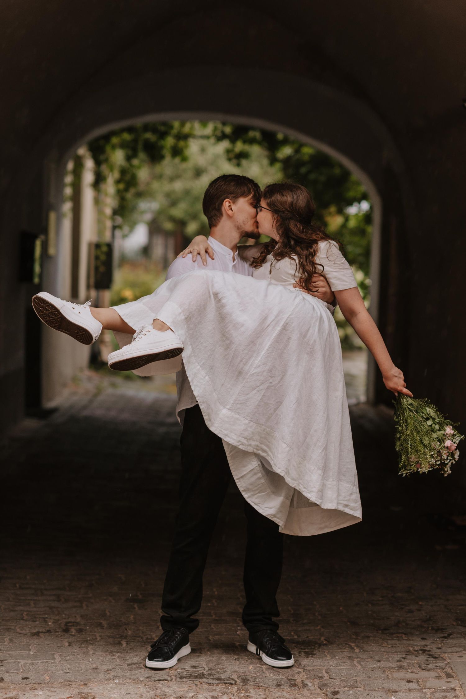 Romantic dance sequence under an archway shows couple in white spinning and embracing.