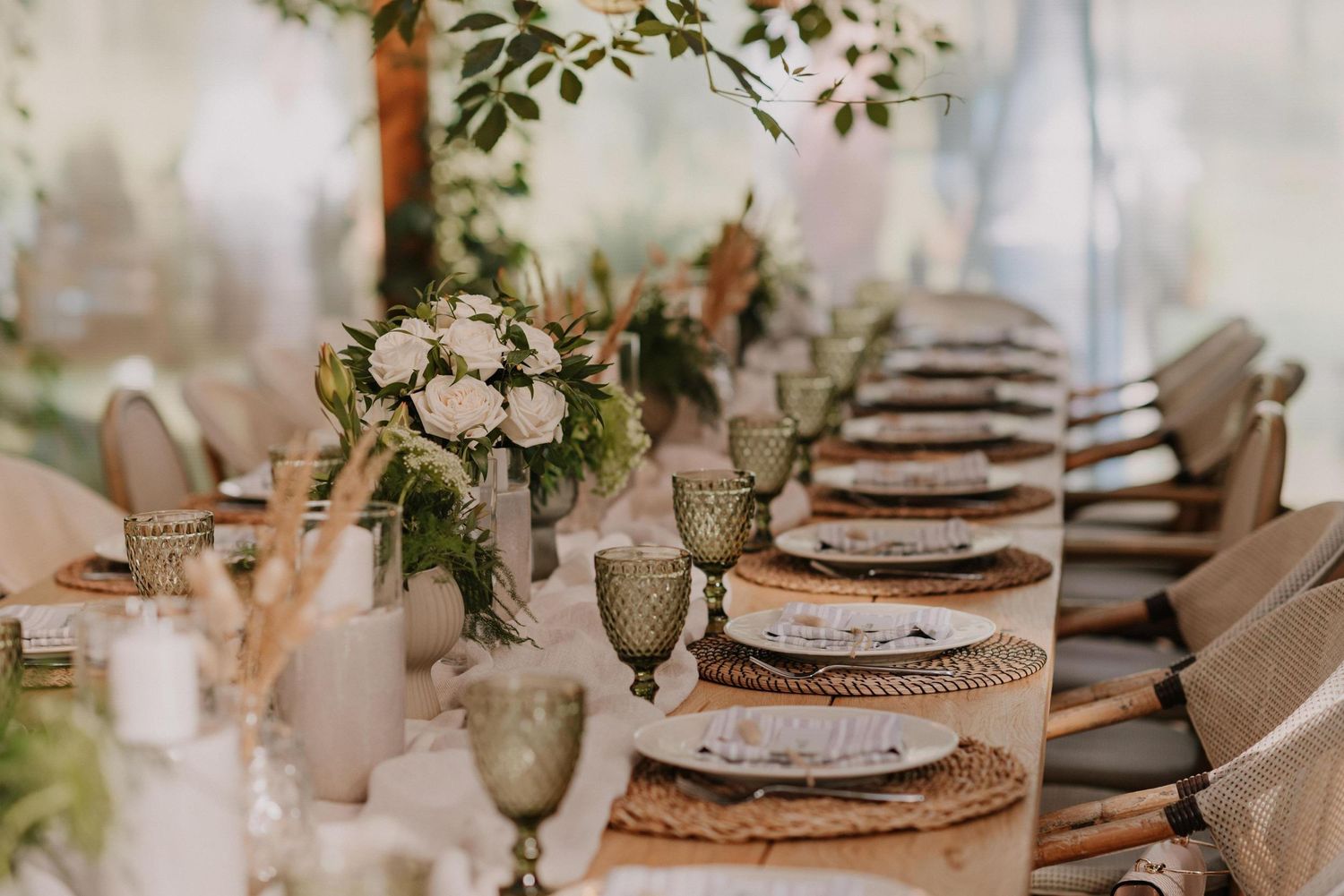 Elegant rustic wedding table settings with floral centerpieces and woven charger plates.