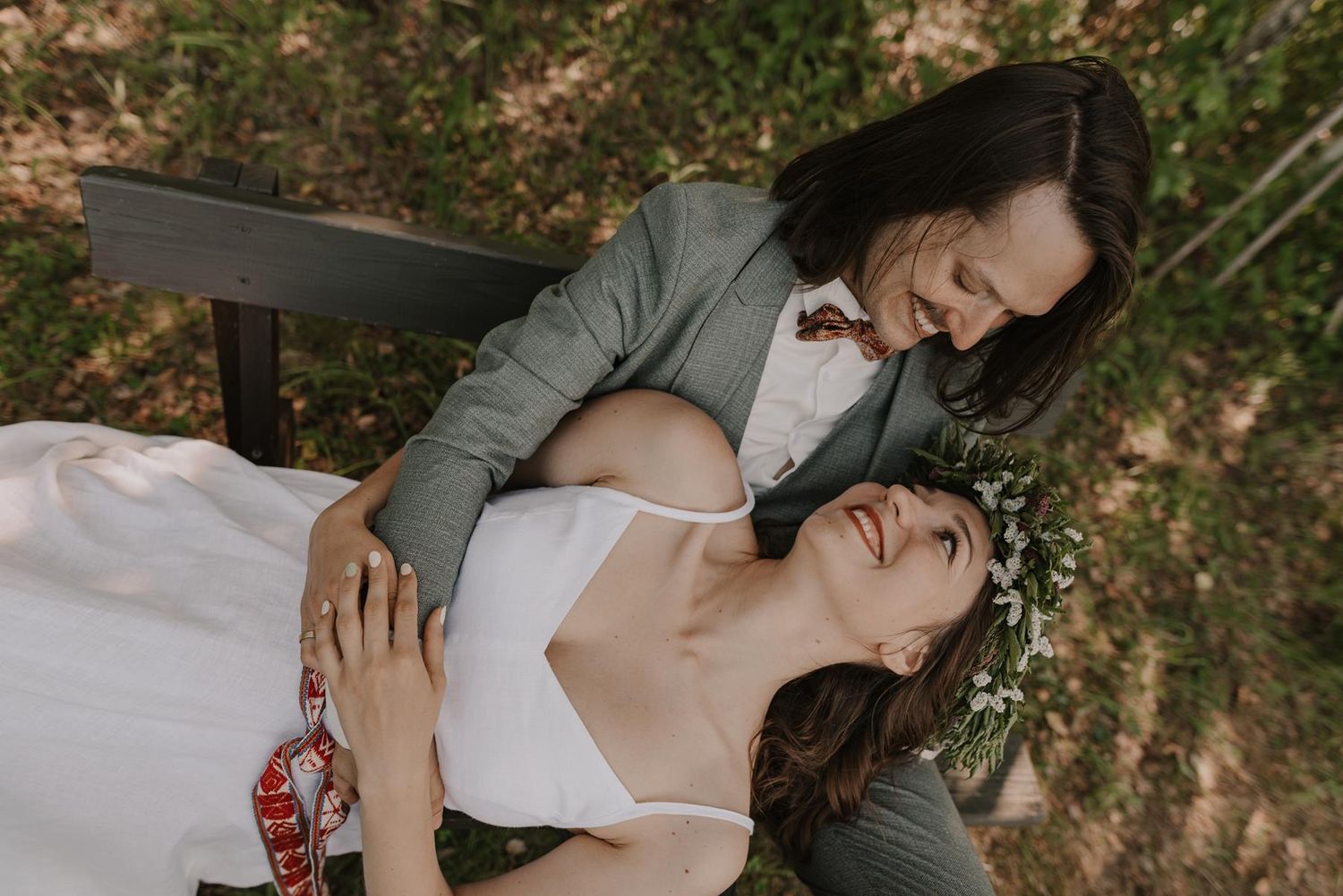 Candid moment between two people sharing laughter on a wooden bench.