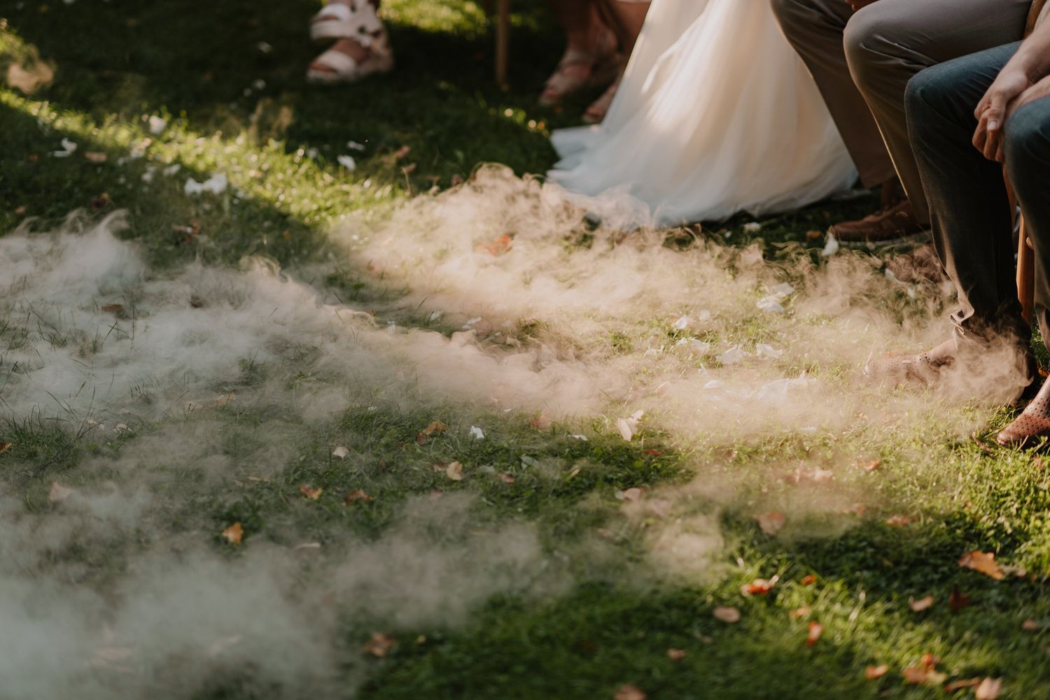 Smoke effect creates dreamy atmosphere at outdoor wedding celebration.