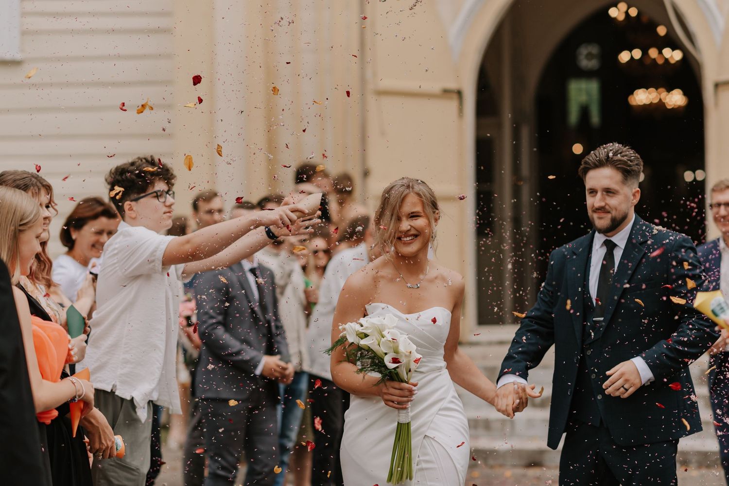 Wedding guests shower the newlyweds with confetti during a joyous celebration.