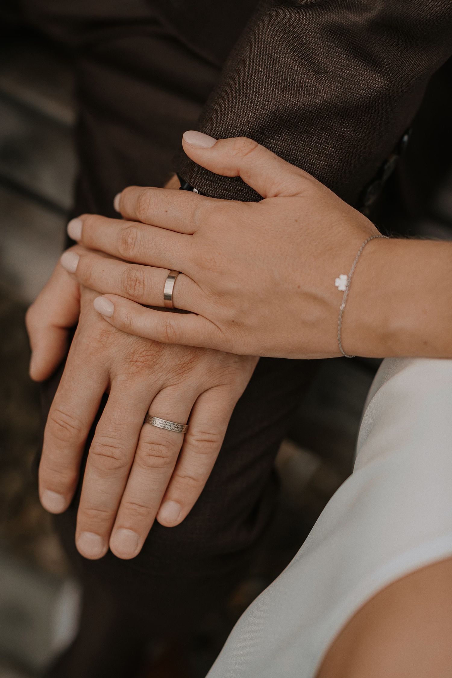 Close-up of wedding rings and hands showing the newly exchanged wedding bands.
