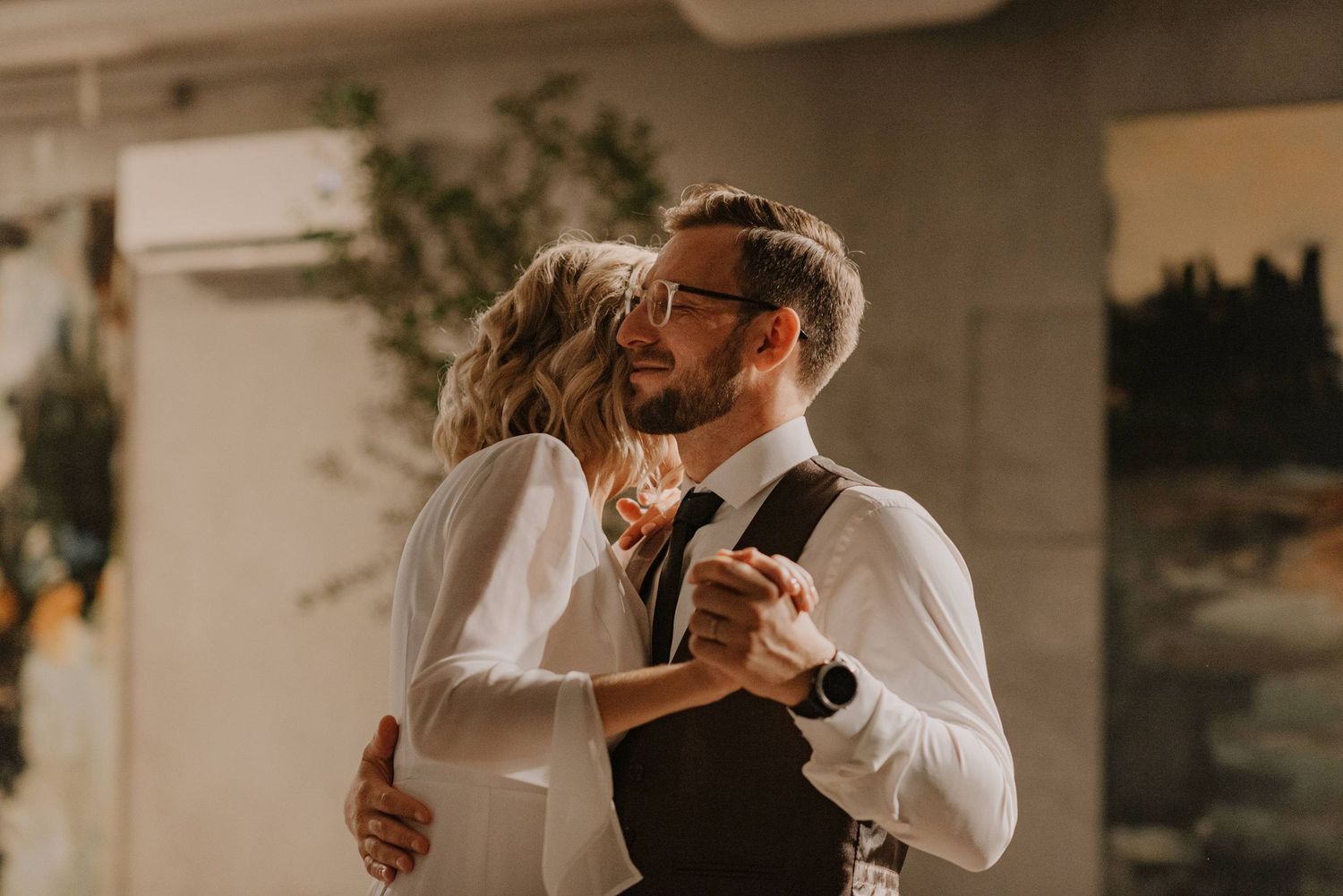 Romantic wedding dance moment captured in warm lighting during reception celebration.