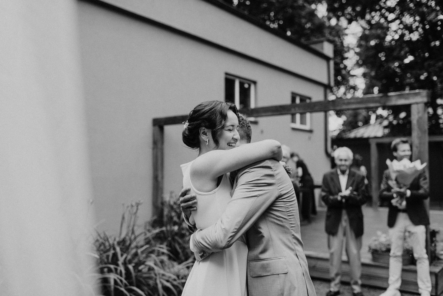 Wedding celebration with guests dancing outdoors under white tent.